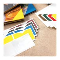 Various colors of Book-Aid® corner protection cloth pieces are shown on adhesive sheets, with some already applied to the corners of book covers for reinforcement.
