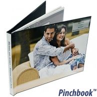 A wedding-themed photo album featuring a smiling couple on the front is bound using Custom Pinchbook™ Photo Book Covers, with a glossy, full-color wraparound design and spine text.
