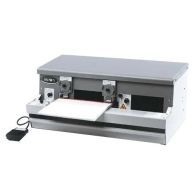 A TCB Pneumatic Two-Sided Cutter and Crimper with a dual cutting and crimping mechanism, featuring two adjustment dials, a foot pedal, and a sturdy metal frame designed for efficiently finishing coil-bound documents.