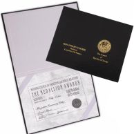 Custom Hardcover Certificate Holders featuring a textured black exterior with gold foil stamping and an interior with corner ribbons to securely display a formal award certificate.