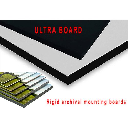 Two large pieces of Heavy Duty Ultra Mount Board with Heat Activated Adhesive, one black and one white, along with a stack of smaller mounted prints, highlighted with text reading "ULTRA BOARD" and "Rigid archival mounting boards."