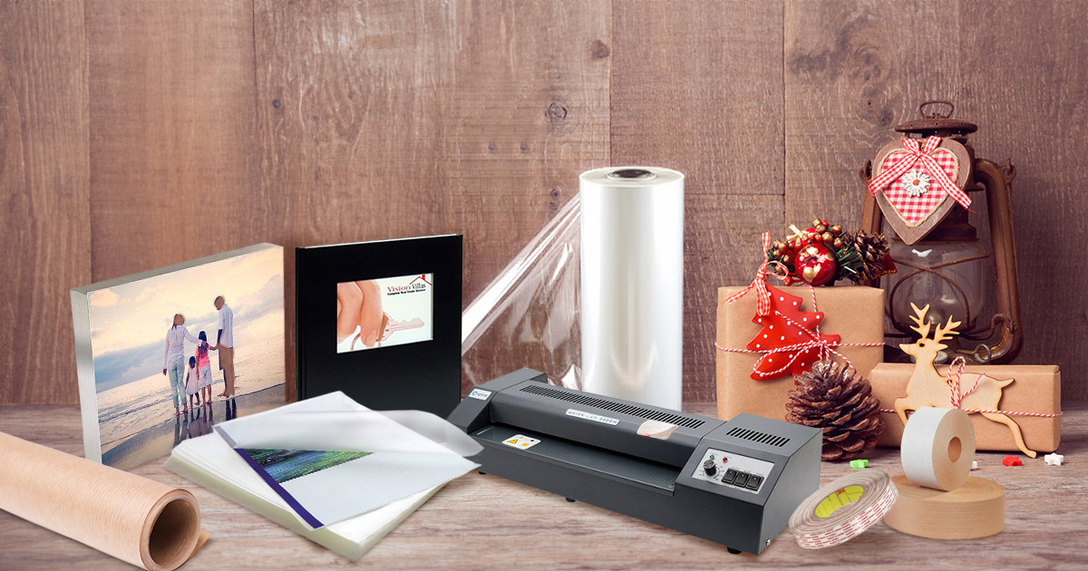 Assortment of foiled holiday cards, laminated bookmark supplies, pinchbooks and photobooks, and binding rings supplies on a  desk.