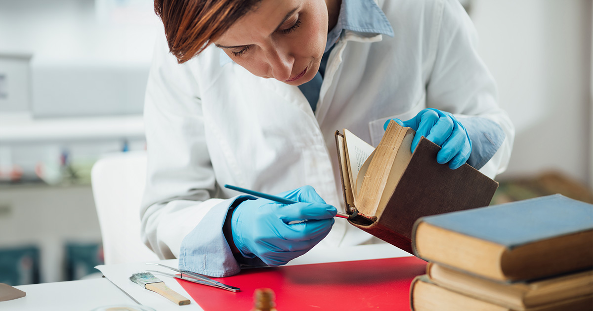 Professional book binder restoring an old book." style=