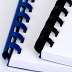 Close-up view of GBC comb bound documents with blue and black spines.