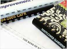 A close-up image of various documents bound with custom printed plastic combs displaying different names and titles.