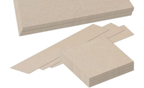 A variety of custom size chipboard sheets including long strips and square pieces arranged in a stack.