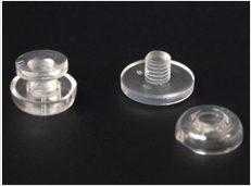 Three clear plastic screw posts arranged on a black background.