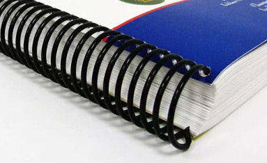Close-up of spiral coil bound documents with a blue cover.