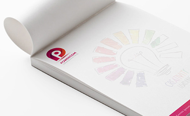 A close-up of notepad paper filled with neatly written text and colorful sketches.
