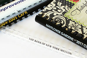 A close-up of various documents bound with custom printed plastic binding combs.